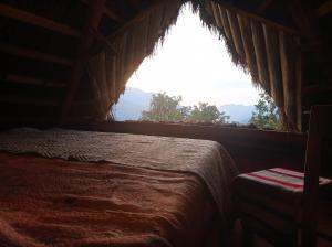 Un dormitorio con una cama y una ventana grande en Eco Albergue Azul, en Cuispes