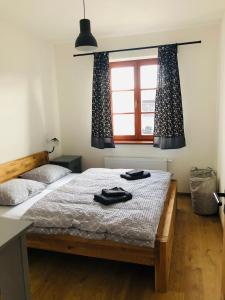 um quarto com uma cama com duas toalhas pretas em Apartmán Kašperky em Kašperské Hory