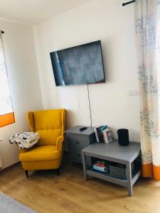 uma sala de estar com uma cadeira amarela e uma mesa em Apartmán Kašperky em Kašperské Hory