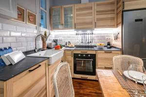 a kitchen with wooden cabinets and a sink and a table at Habitat Apartments Alaia in Barcelona