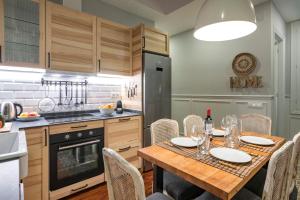 a kitchen with a wooden table with chairs and a dining room at Habitat Apartments Alaia in Barcelona
