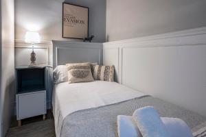 - une petite chambre avec un lit et une télévision dans l'établissement Habitat Apartments Alaia, à Barcelone