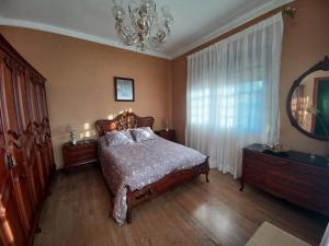 a bedroom with a bed and a mirror and a chandelier at Caserío Félix in Baralla