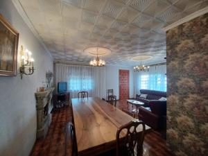 a dining room and living room with a wooden table at Caserío Félix in Baralla