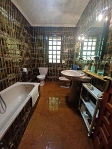 een badkamer met 2 wastafels, een bad en 2 toiletten bij Caserío Félix in Baralla