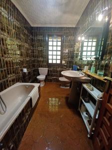 a bathroom with two sinks a tub and two toilets at Caserío Félix in Baralla +32 photos