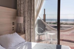a bedroom with a bed and a balcony with a hammock at Hotel Campanario Del Mar in La Serena