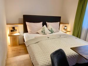 una camera con un letto, una sedia e un tavolo di Gasthof Rieder Stubn Hotel#Restaurant#Pinseria a Ried im Oberinntal