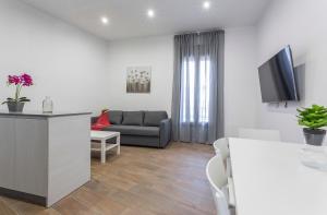 un soggiorno con un divano e una TV di Doña Blanca Centro Diseño Minimalista a Jerez de la Frontera