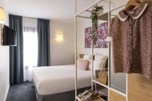 - une chambre d'hôtel avec un lit et un miroir dans l'établissement Hotel Paris Louis Blanc, à Paris