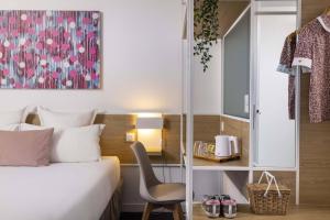 ein Hotelzimmer mit einem Bett und einem Stuhl in der Unterkunft Hotel Paris Louis Blanc in Paris