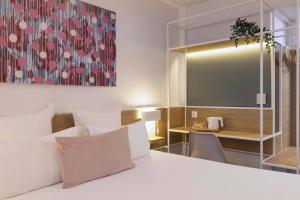 パリにあるホテル パリ ルイ ブランのベッドとテーブルが備わるホテルルームです。