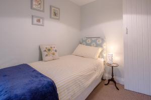 Habitación pequeña con cama y mesa pequeña en 2 Riverside Cottages, en Saxmundham