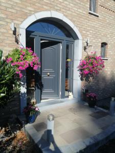een deur van een huis met bloemen ervoor bij Gite Appartement "Le bel étage" jacuzzi piscine 6 Personnes in Godinne
