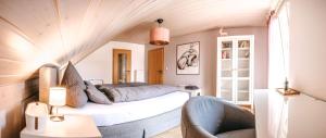 niewielka sypialnia z łóżkiem i krzesłem w obiekcie hirsch in pink - wohnen wie zuhause w mieście Türkheim