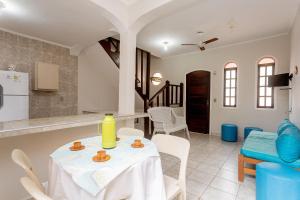 kuchnia i salon ze stołem i krzesłami w obiekcie Chalés por temporada no Villagio Santa Mônica, em Caraguatatuba w mieście Caraguatatuba