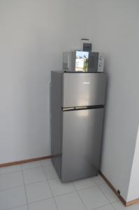 a refrigerator with a microwave on top of it at Bluestar Appartement 4, centre de Grand Baie in Grand Baie