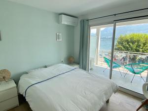 a bedroom with a bed and a view of the ocean at Pieds dans l'eau au lac du Bourget in Le Bourget-du-Lac