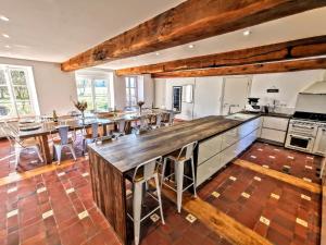 a large kitchen with wooden floors and a long table at Le Moulin des Ducs in Épinac-les-Mines