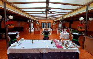 Hotel Santa Cecilia في سيوداد ريال: غرفة طعام بها طاولات وكراسي وسقف
