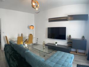 uma sala de estar com um sofá azul e uma mesa em Modern & cozy 2 bed bungalow em Horden