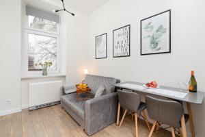 a living room with a couch and a table at Studio Cracow Wawrzyńca by Renters in Krakow