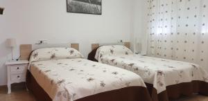 ベニドルムにあるFMM Apartamentos La Nucía Benidorm Holidays Apartmentsのカーテン付きの客室で、ツインベッド2台が備わります。