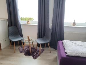 1 dormitorio con 2 sillas, mesa y ventana en Glemmy Appartements inkl Sommercard, en Viehhofen