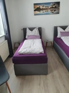 1 Schlafzimmer mit 2 Betten und lila Bettwäsche in der Unterkunft Glemmy Appartements inkl Sommercard in Viehhofen