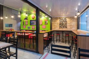 a restaurant with a bar and tables and chairs at Rezende Suítes Hotel in Balneário Camboriú