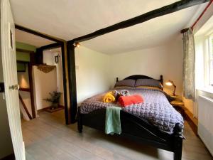 a bedroom with a bed with a stuffed animal on it at Beautiful 500 year old listed Kentish cottage in Wingham