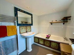 a bathroom with a sink and a tub next to a sink at Beautiful 500 year old listed Kentish cottage in Wingham