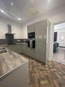 una cucina con elettrodomestici in acciaio inossidabile e pavimenti in legno di Modern & cozy 2 bed bungalow a Horden