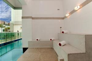 a room with a bench and a swimming pool at Jade Hotel Brasília in Brasilia