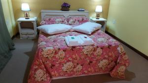 a bedroom with a pink bed with two pillows at Suíte com vista da Serra in Teresópolis