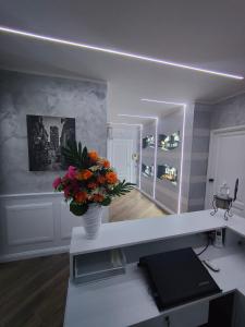 a room with a vase of flowers on a desk at B&B MaisonAlysie in Foggia