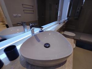 une salle de bain avec un lavabo blanc et un miroir dans l'établissement Boutique Studio, à Alghero