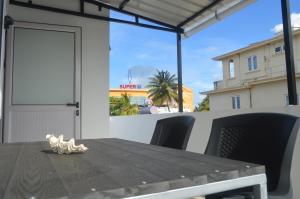 a table and chairs with a view of a building at Bluestar Appartement 5, centre de Grand Baie in Grand Baie