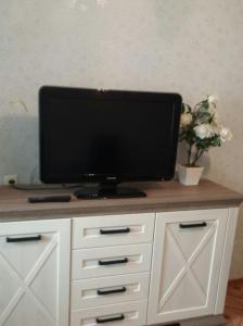 a flat screen tv sitting on top of a white cabinet at Center Tiraspol in Tiraspol