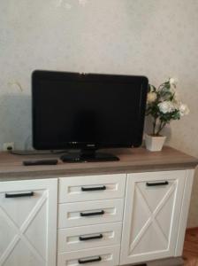 una TV a schermo piatto seduta sopra un armadio bianco di Center Tiraspol a Tiraspol