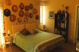 a bedroom with a bed and a shelf with hats on the wall at LA CUCCAGNA DI DON BOSCO - No landlords and neighbours - Absolute privacy! in Montafia