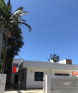 un edificio blanco con una flecha roja. en Residêncial Casa da Vila apto 1, en Imbituba
