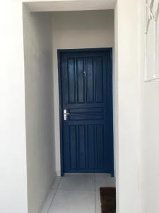 une porte bleue dans une pièce dotée d'un mur blanc dans l'établissement Residêncial Casa da Vila apto 1, à Imbituba