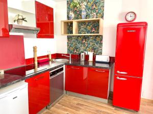 a kitchen with red cabinets and a red refrigerator at Art Apparts Chaudronniers in Béziers