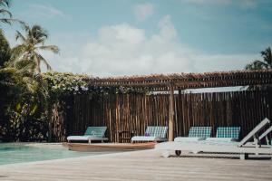 a pool with lounge chairs next to a fence at Pousada Café Zapata in Amontada