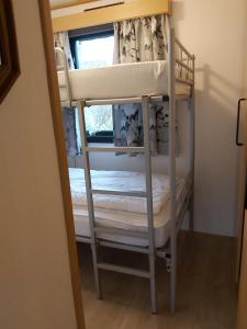 a bunk bed in a room with a window at Comfortabel en gezellig familie chalet tot 6 personen op de Veluwe Bungalowpark De Kern - All inclusive in Putten