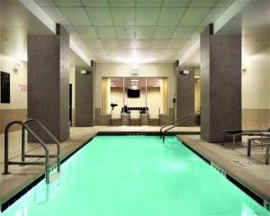 a swimming pool with blue water in a building at Hyatt Place Des Moines Downtown in Des Moines