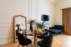 a living room with a table and a mirror at Suite Ocre in Lyon