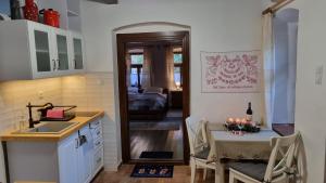 a kitchen and dining room with a table and a sink at Hutai Meseház in Háromhuta