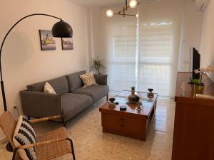 Apartamento Acebuche 34 - Newly renovated في رينكون دي لا فيكتوريا: غرفة معيشة مع أريكة وطاولة قهوة